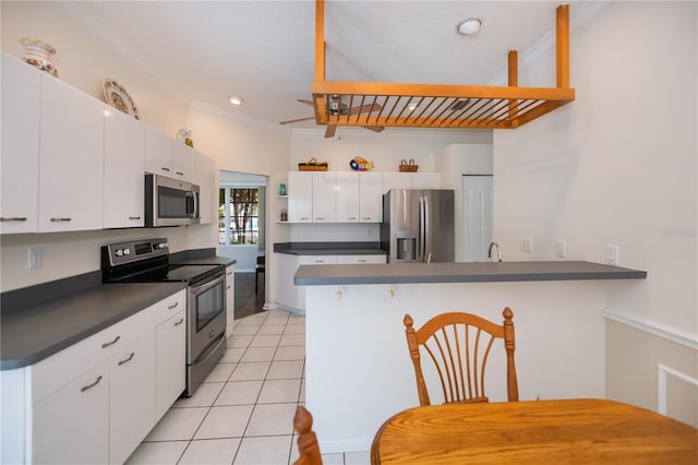 kitchen with ornamental molding, open shelves, a peninsula, dark countertops, and stainless steel appliances
