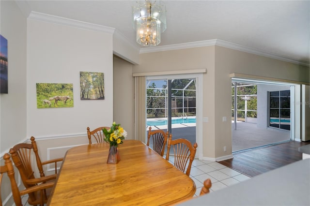 dining space with crown molding, baseboards, an inviting chandelier, and wood finished floors