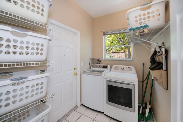 washroom featuring washer and dryer, laundry area, and light tile patterned floors