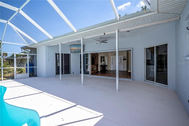 rear view of house featuring a lanai, an outdoor pool, a patio area, and stucco siding