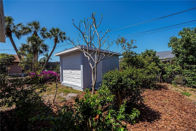 view of outbuilding featuring fence and an outdoor structure