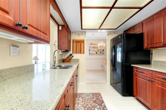 810 Anchorage Ln, Palm Harbor, FL 34685 - kitchen featuring a sink, light tile patterned floors, freestanding refrigerator, light stone countertops, and a chandelier