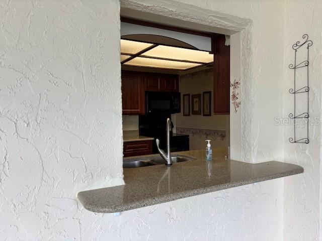 810 Anchorage Ln, Palm Harbor, FL 34685 - kitchen with a sink, black microwave, and stone counters