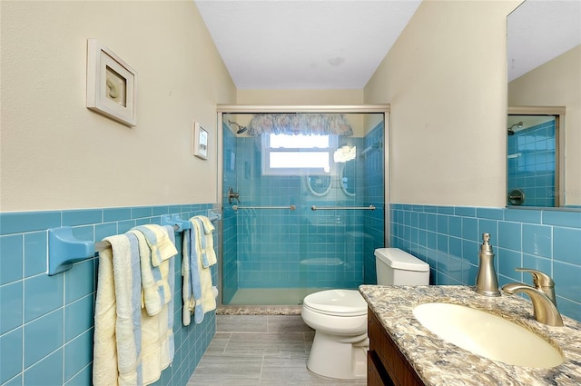 810 Anchorage Ln, Palm Harbor, FL 34685 - bathroom with tile walls, vanity, a shower stall, toilet, and a wainscoted wall