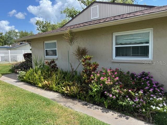 810 Anchorage Ln, Palm Harbor, FL 34685 - view of property exterior featuring a shingled roof and stucco siding