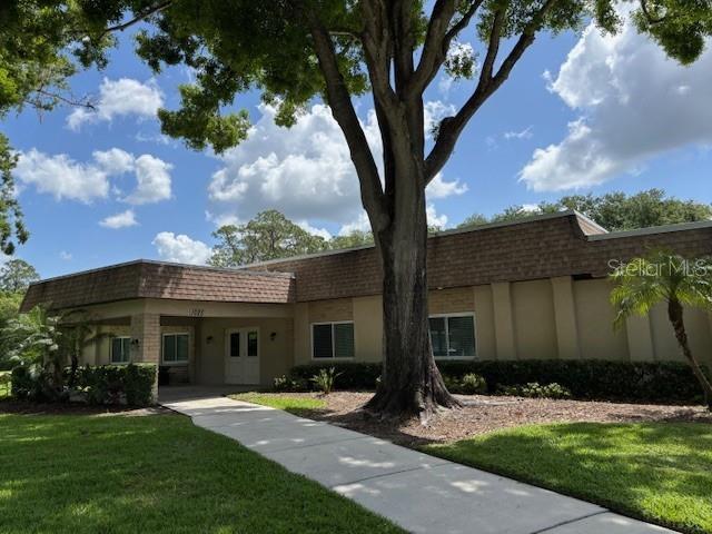 810 Anchorage Ln, Palm Harbor, FL 34685 - view of front facade with mansard roof, a front lawn, and a shingled roof