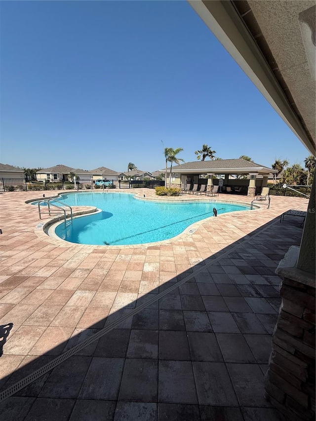 community pool featuring fence and a patio