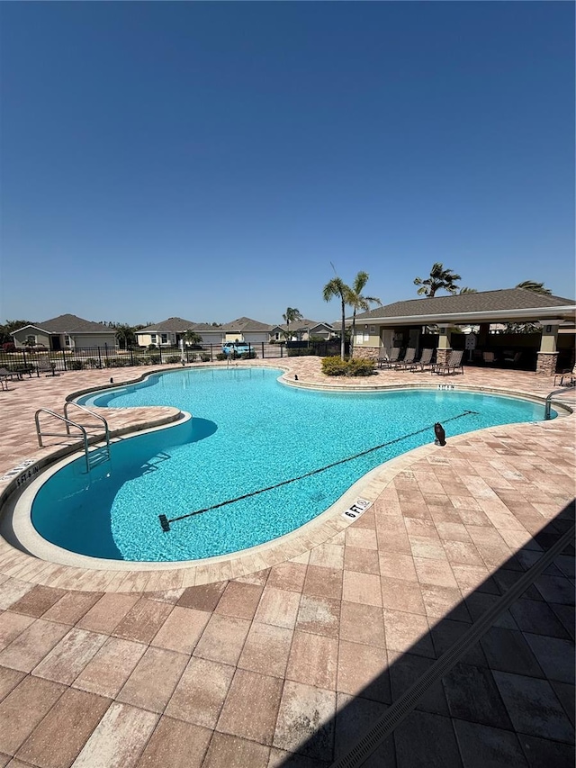 pool with a patio and fence