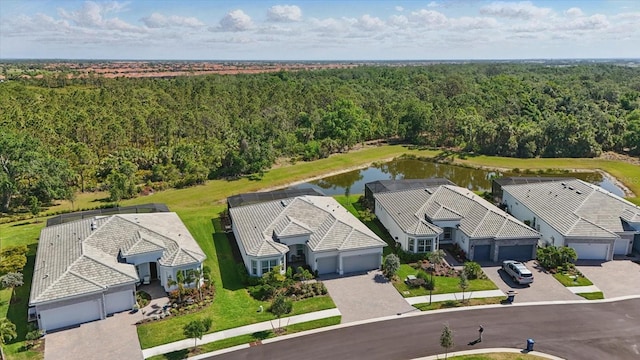 birds eye view of property featuring a water view and a forest view
