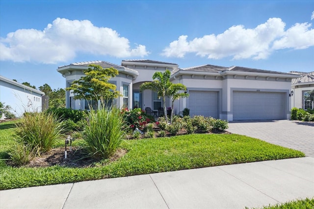 view of front of home featuring a garage, stucco siding, and decorative driveway