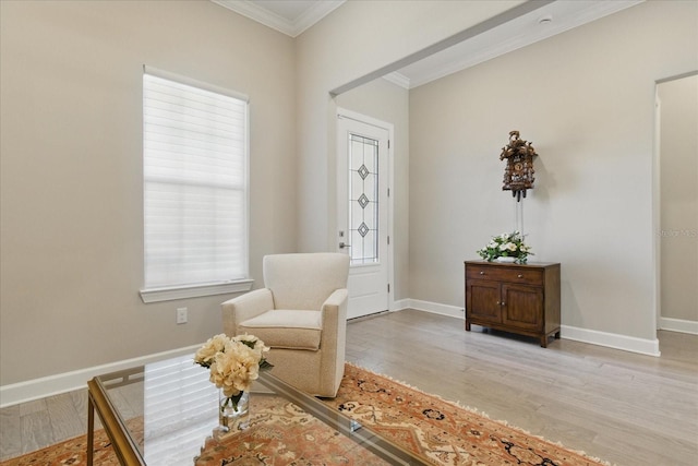 living area with crown molding, baseboards, and light wood-type flooring