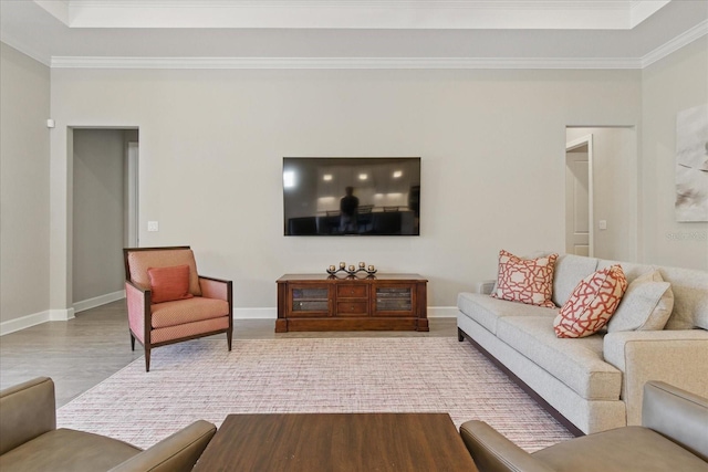 living area with crown molding, baseboards, and wood finished floors