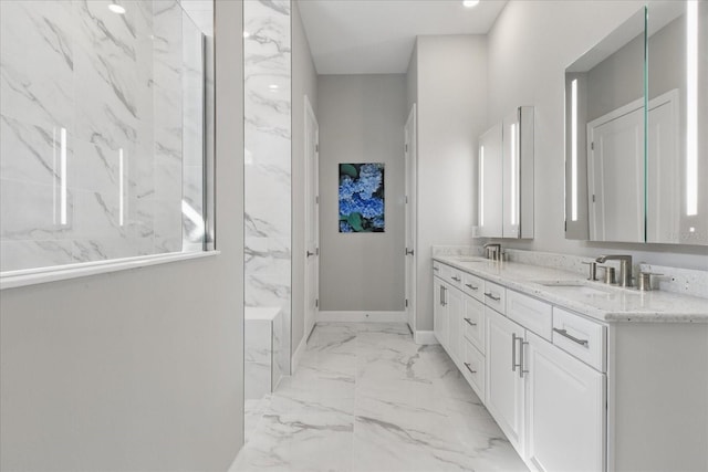 full bath with a sink, baseboards, double vanity, and marble finish floor