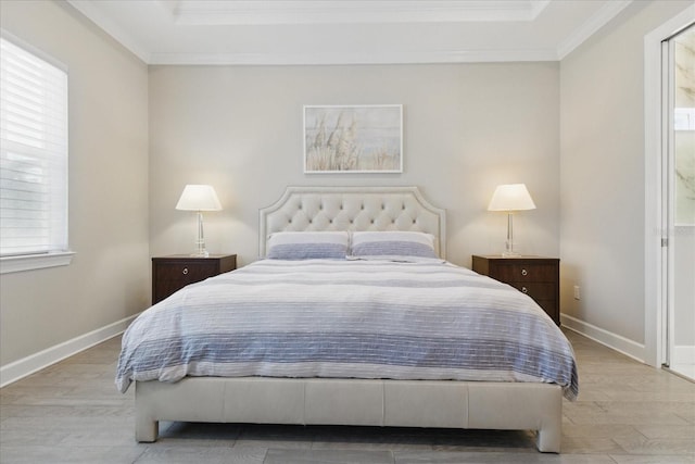 bedroom with a raised ceiling, multiple windows, crown molding, and wood finished floors