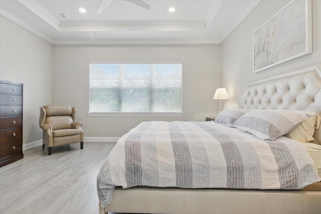 bedroom featuring a tray ceiling, crown molding, wood finished floors, and baseboards