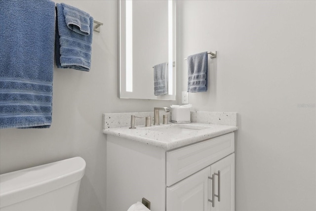 half bathroom with toilet and vanity
