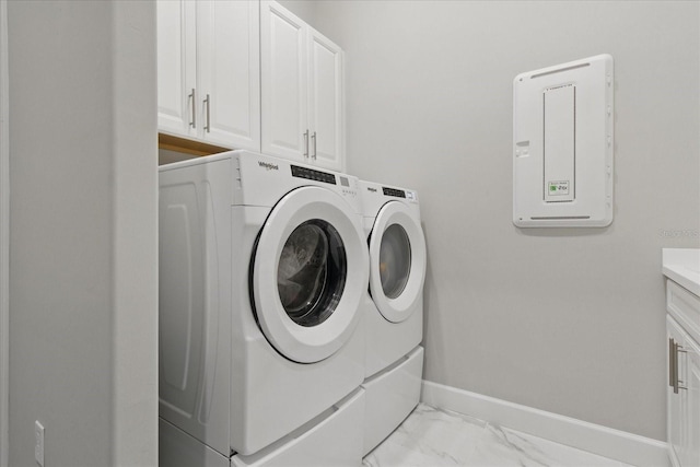 washroom with cabinet space, independent washer and dryer, marble finish floor, and baseboards