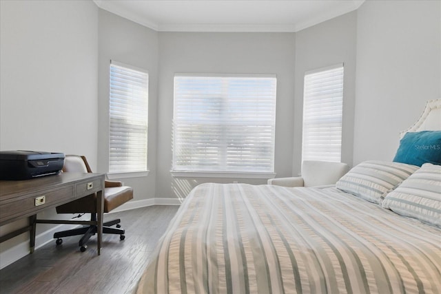 bedroom with ornamental molding, baseboards, and wood finished floors