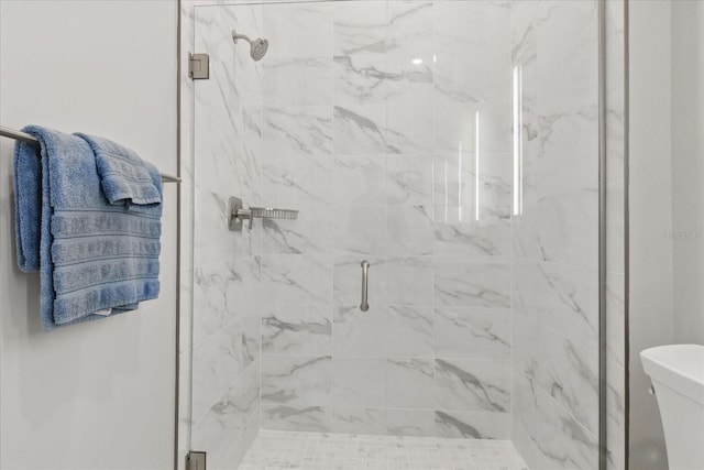 bathroom with a marble finish shower and toilet