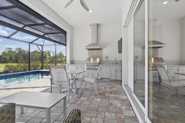 view of patio / terrace with area for grilling, ceiling fan, a sink, and glass enclosure