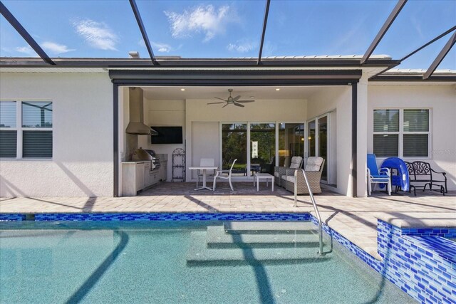 back of house with exterior kitchen, a patio area, stucco siding, and a lanai