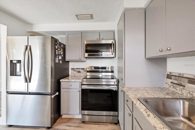 5755 Oxalis Rd, Venice, FL 34293 - kitchen featuring appliances with stainless steel finishes, gray cabinetry, a sink, and visible vents