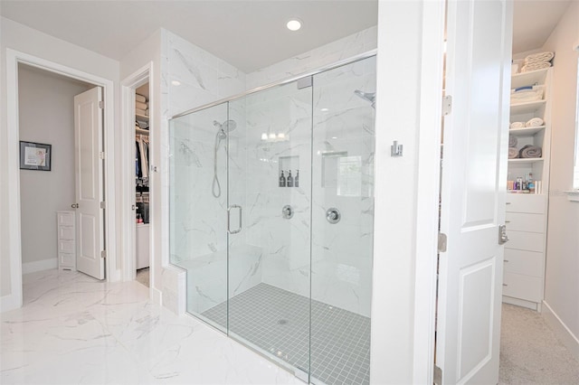bathroom with a marble finish shower, a spacious closet, recessed lighting, and baseboards