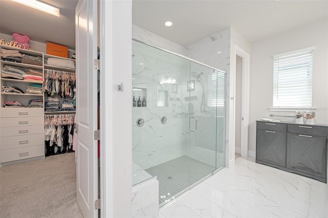 full bath with a marble finish shower, a walk in closet, and recessed lighting