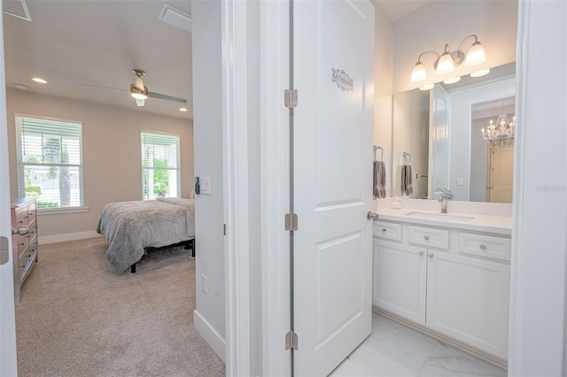 ensuite bathroom with ceiling fan with notable chandelier, connected bathroom, vanity, recessed lighting, and baseboards