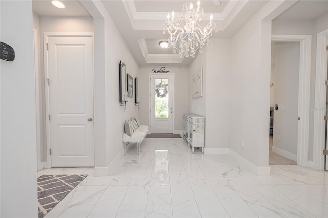 bathroom featuring baseboards, an inviting chandelier, crown molding, a raised ceiling, and marble finish floor