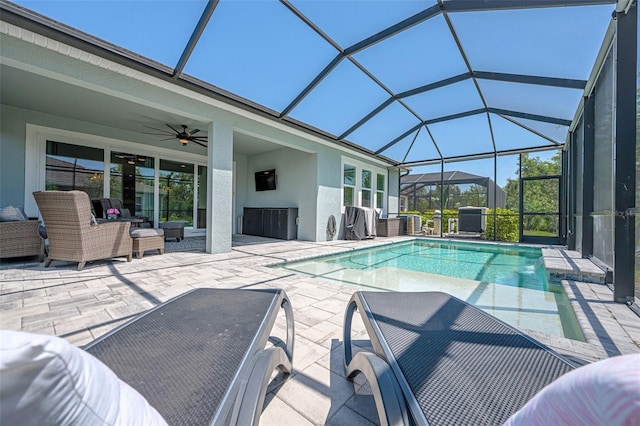 outdoor pool featuring a patio area, an outdoor living space, glass enclosure, and ceiling fan
