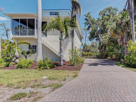view of home's exterior featuring stucco siding, stairs, and decorative driveway