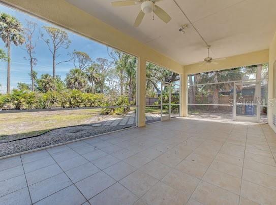unfurnished sunroom with ceiling fan