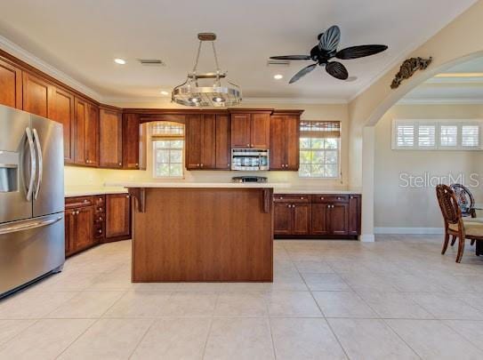 kitchen featuring crown molding, stainless steel appliances, light countertops, and plenty of natural light