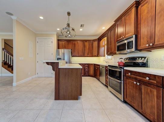 kitchen featuring stainless steel appliances, ornamental molding, light tile patterned floors, a kitchen island, and a notable chandelier