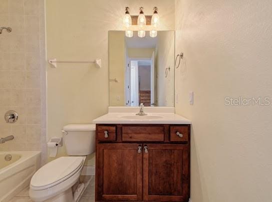 bathroom with  shower combination, toilet, vanity, and tile patterned floors