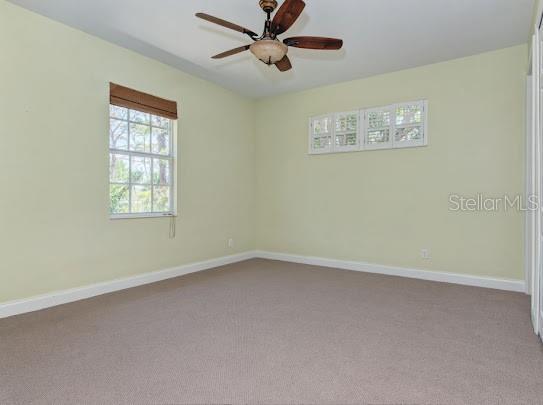 unfurnished room with carpet floors, baseboards, and ceiling fan