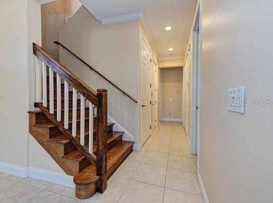 stairway with baseboards, tile patterned flooring, recessed lighting, and crown molding