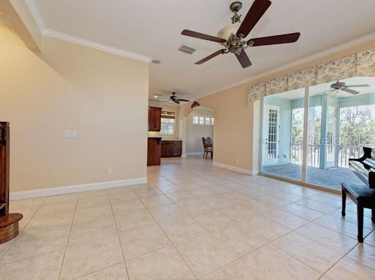 unfurnished living room with ceiling fan and ornamental molding