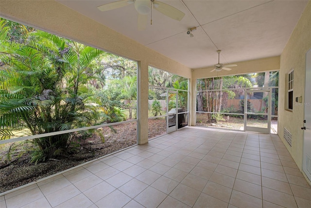 unfurnished sunroom featuring ceiling fan
