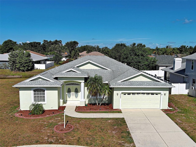 view of front of house with an attached garage, concrete driveway, and a shingled roof