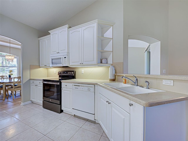 kitchen with white appliances, a sink, open shelves, arched walkways, and tasteful backsplash