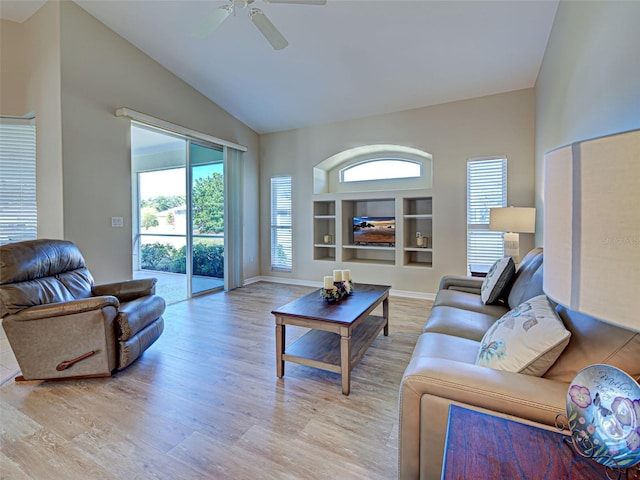 living area with lofted ceiling, light wood finished floors, a ceiling fan, baseboards, and built in features