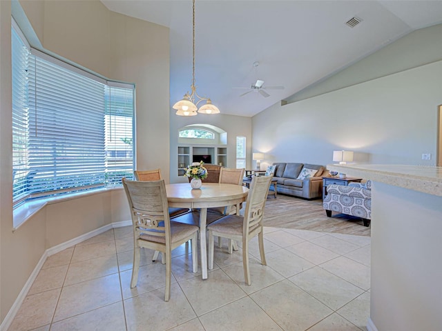 dining space with lofted ceiling, a chandelier, light tile patterned flooring, baseboards, and ceiling fan