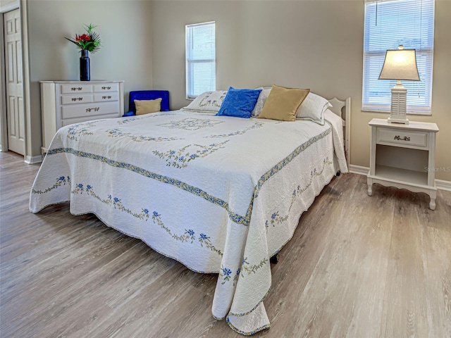 bedroom featuring wood finished floors and baseboards