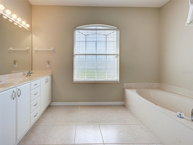 bathroom featuring tile patterned flooring, a bath, baseboards, and double vanity