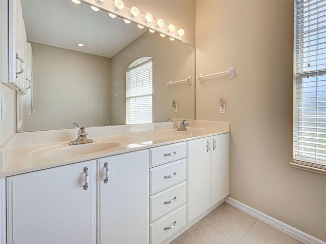 full bath with tile patterned flooring, baseboards, and double vanity