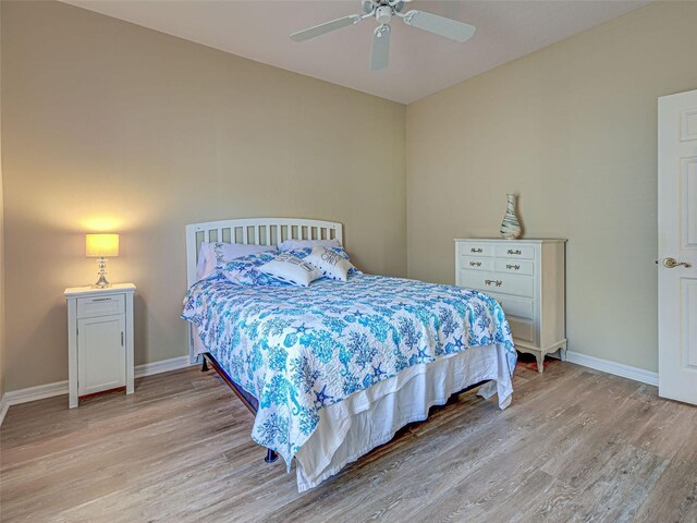 bedroom featuring light wood-type flooring, baseboards, and a ceiling fan
