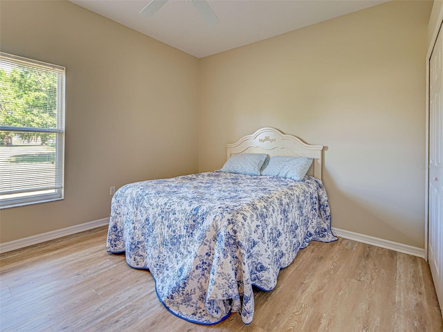 bedroom featuring wood finished floors, baseboards, and ceiling fan