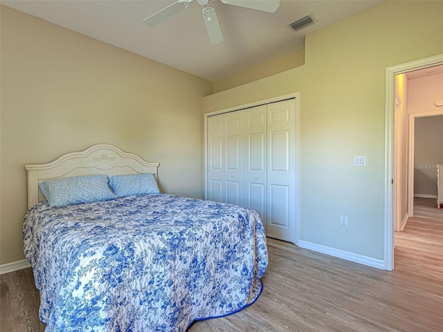 bedroom featuring wood finished floors, baseboards, a closet, and a ceiling fan